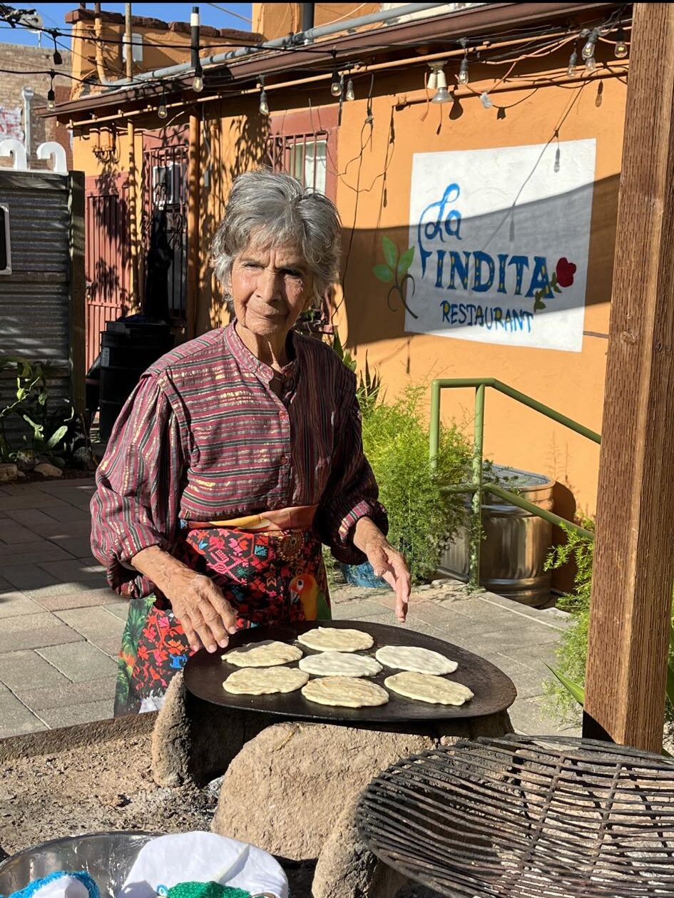 A photo of founder Maria Garcia cooking tortillas outside of La Indita on the patio