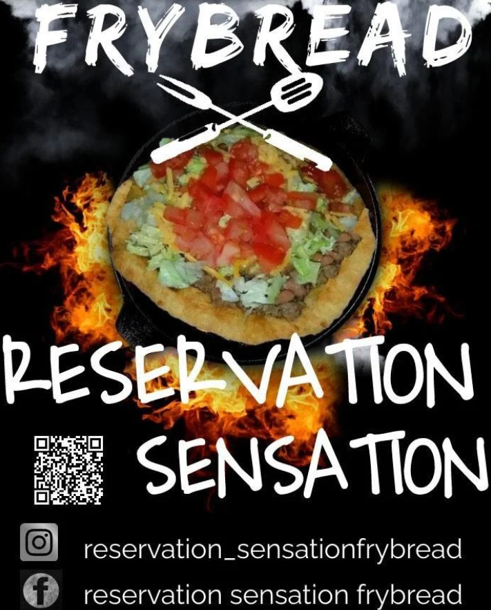 Frybread Reservation Sensation a picture with an "Indian Taco" which is frybread with meat, lettcue, cheese and tomatoes. The background is black with flames